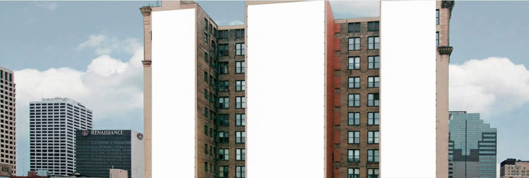 Trabajos de instalación de una lona publicitaria en la medianera de un edificio del centro de Madrid