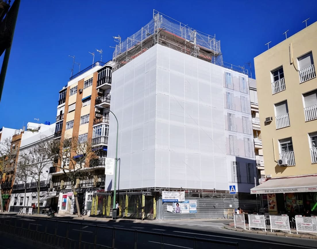 Lona publicitaria de gran formato colocada sobre un andamio de rehabilitación en Madrid