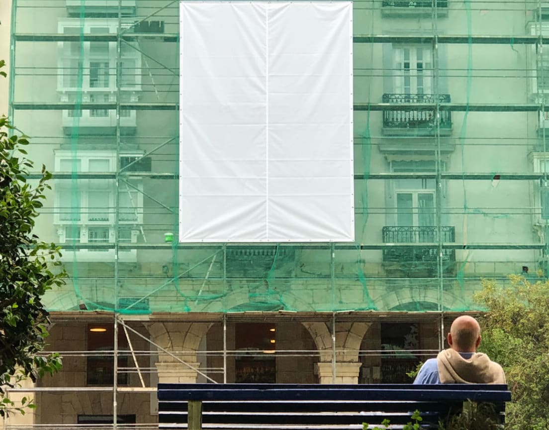 Lona publicitaria instalada en un andamio utilizada para financiar obras de una comunidad