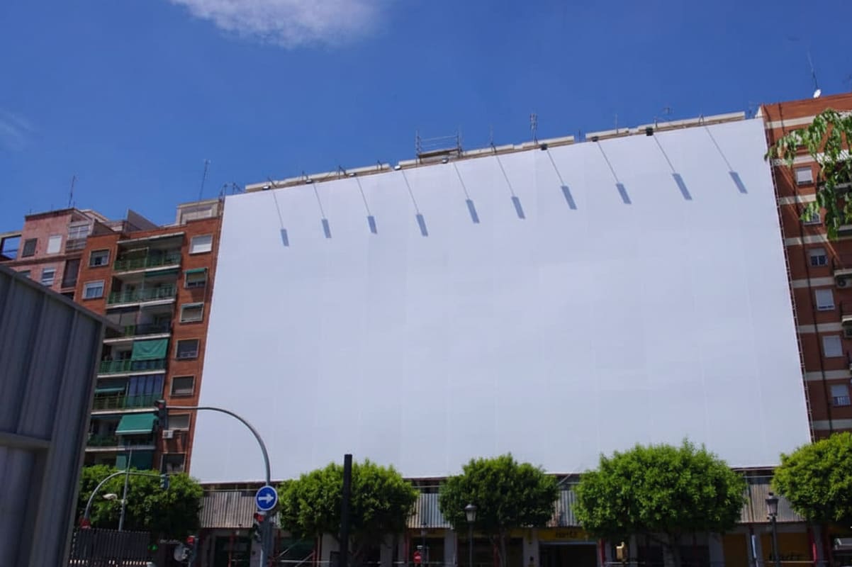 Lona publicitaria instalada en un andamio de un edificio de Madrid con montaje profesional
